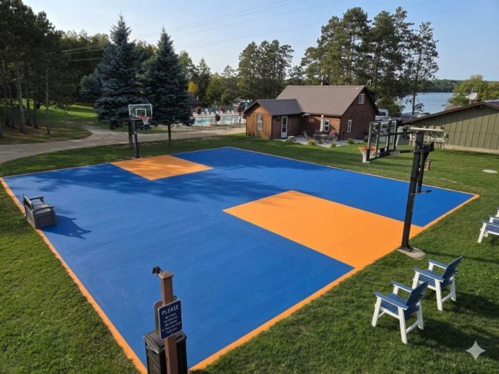 Outdoor basketball court with blue and orange tiles near lake
