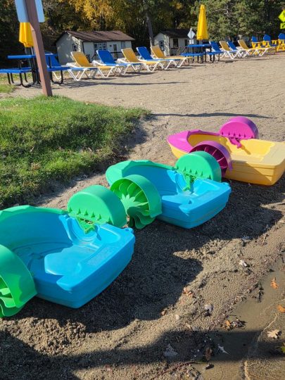 Colorful paddle boats resting on sandy beach at resort