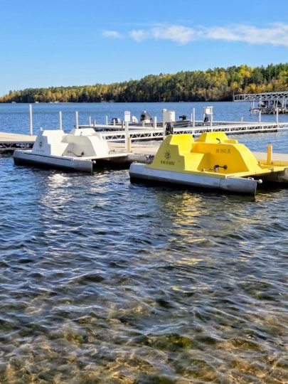 Yellow and white paddle boats docked at lake marina