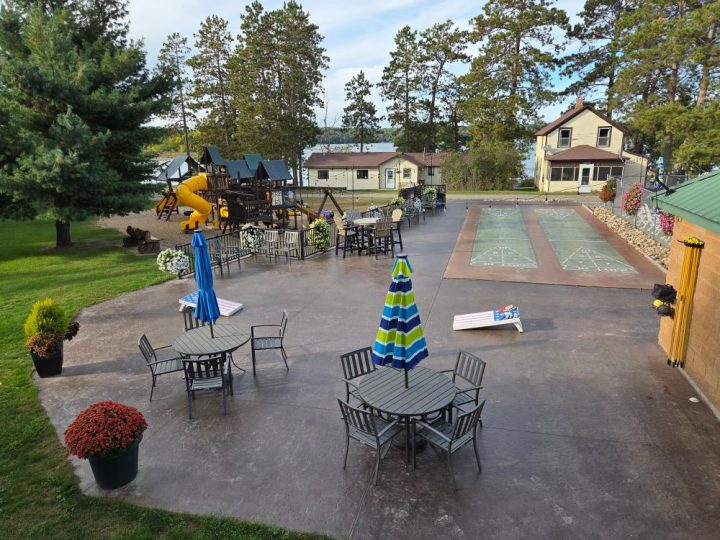 Lakeside resort patio with shuffleboard, playground, and seating
