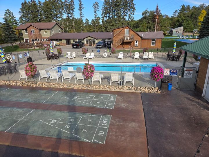 Resort pool area with shuffleboard court and lounge chairs